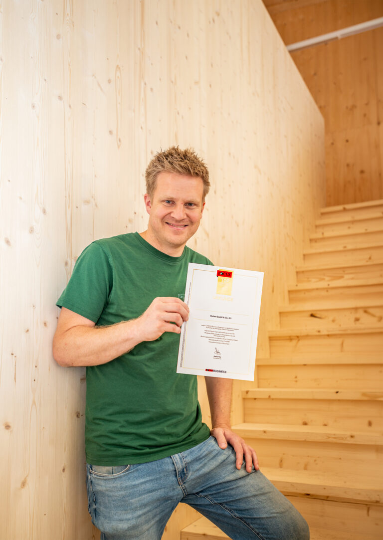 Dominic Huber zeigt die Auszeichnung vom Magazin Focus zum TOP-Arbeitgeber