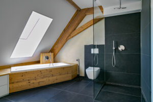 Maßgefertigte Holz-Badmöbel und Waschtisch unter Dachschräge im modernen Badezimmer.