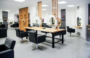 Objekteinrichtung nach Maß: Friseursalon mit individuellen Holz-Arbeitsplätzen und Beleuchtung.
